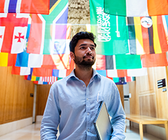 UCD student walking under flags.